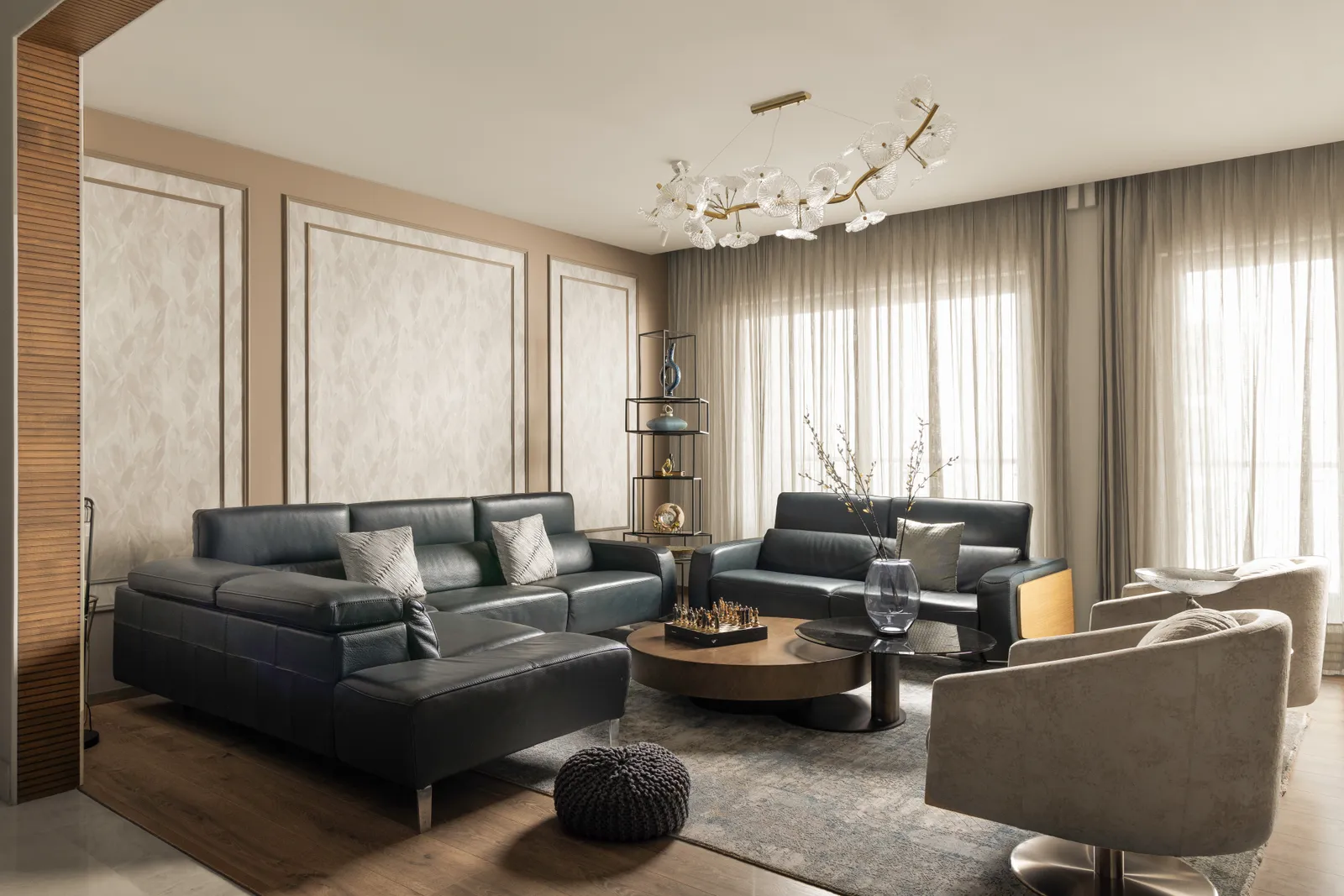 Living room with dark leather sofas, sculptural chandelier and panelled walls — Seema Katta Svasa